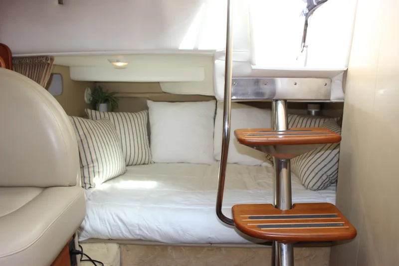 Slide: The Image of 2004 Rinker 342 Express Cruiser interior with cozy bed and striped pillows. - 31