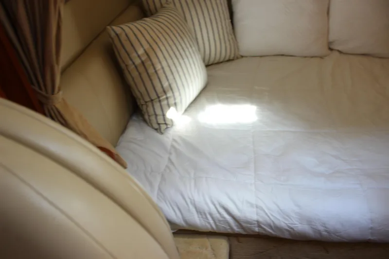 Slide: The Image of Interior of 2004 Rinker 342 Express Cruiser with cozy bedding and striped pillows. - 33