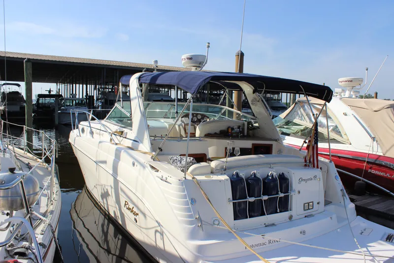 Slide: The Image of 2004 Rinker 342 Express Cruiser docked at marina, featuring spacious deck and canopy. - 4