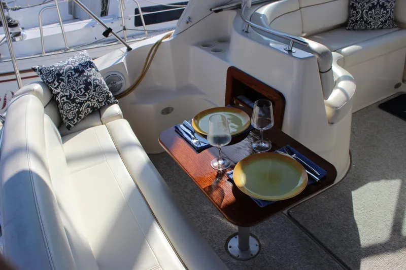 Slide: The Image of 2004 Rinker 342 Express Cruiser interior with dining setup on deck. - 7
