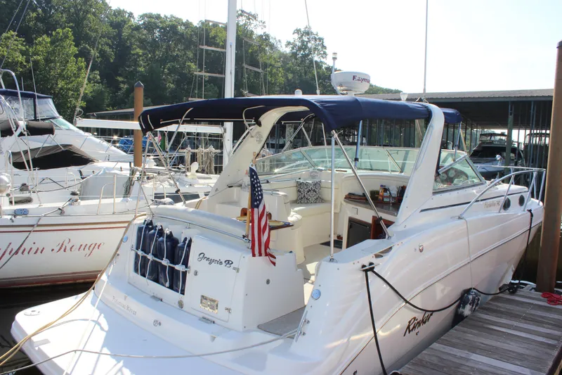 Slide: The Image of 2004 Rinker 342 Express Cruiser docked with American flag, surrounded by other boats. - 5