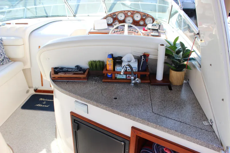 Slide: The Image of 2004 Rinker 342 Express Cruiser cockpit with sink, storage, and dashboard controls. - 9