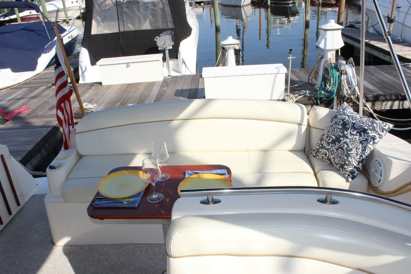 Slide: The Image of 2004 Rinker 342 Express Cruiser interior with elegant seating, table setting, and decorative pillow. - 16
