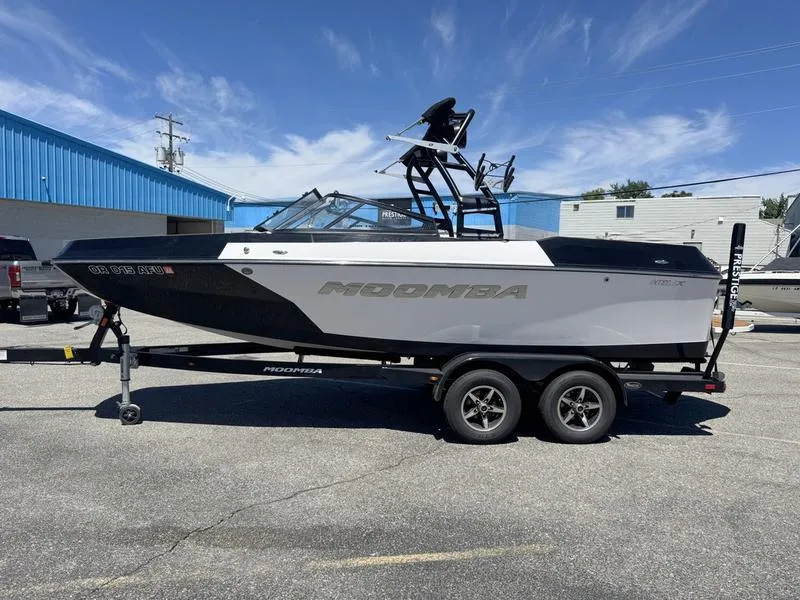 Slide: The Image of 2017 Moomba Helix boat on trailer, parked outdoors under clear blue sky. - 0