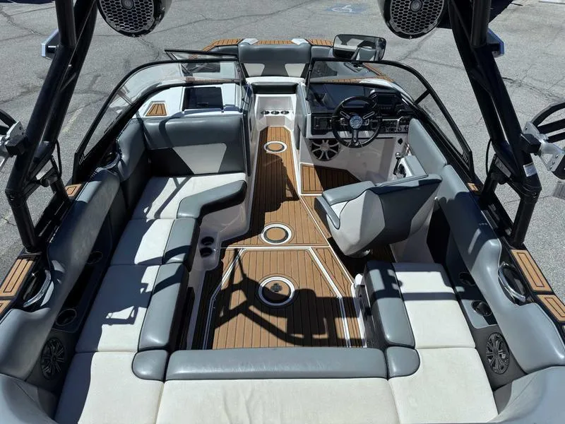 Slide: The Image of 2017 Moomba Helix boat interior with gray seating and wood accents, featuring a modern dashboard. - 22