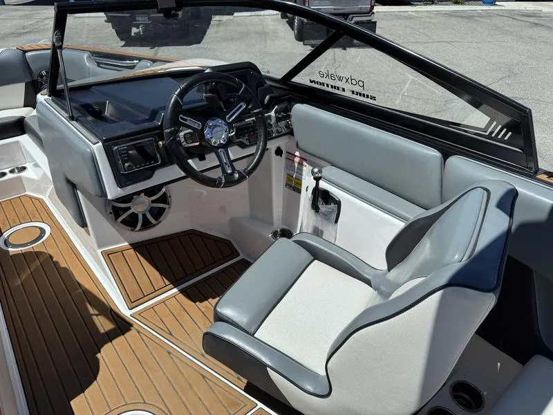 Slide: The Image of 2017 Moomba Helix boat interior with steering wheel and seating, featuring wood-style flooring. - 24