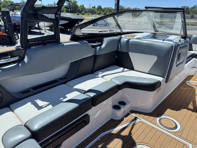 Slide: The Image of 2017 Moomba Helix boat interior with gray seating and wooden deck. - 25