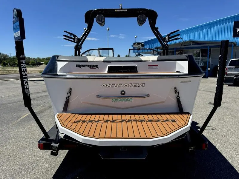 Slide: The Image of 2017 Moomba Helix boat rear view with teak deck, parked outdoors. - 3
