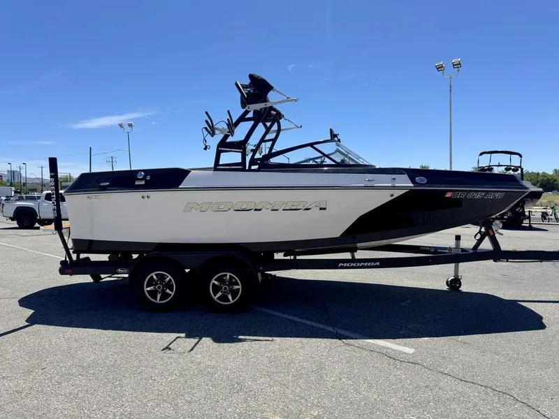 Slide: The Image of 2017 Moomba Helix boat on trailer in parking lot under clear blue sky. - 4