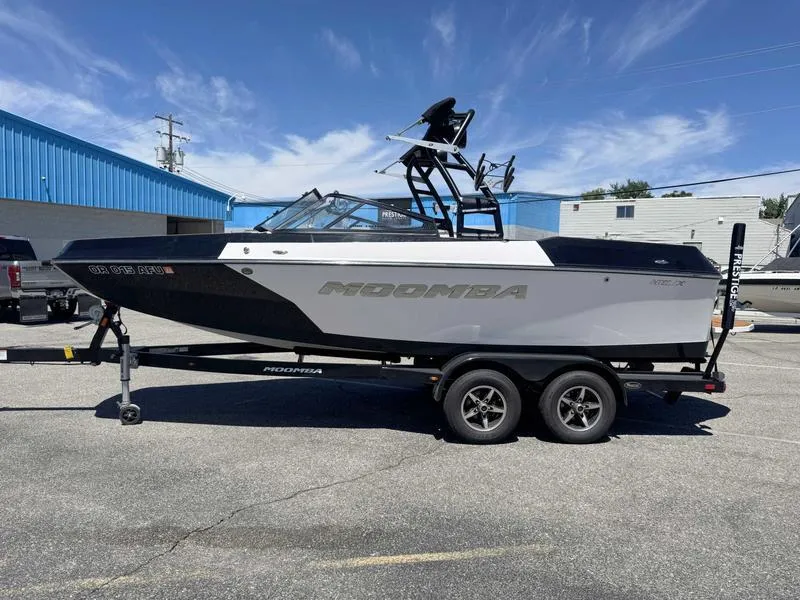 Slide: The Image of 2017 Moomba Helix boat on trailer, parked outdoors under clear sky. - 9