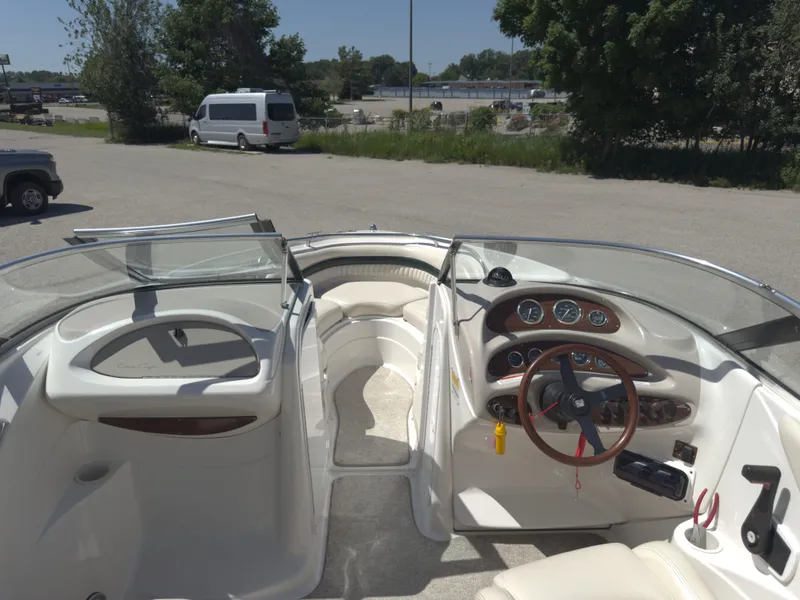Slide: The Image of 1999 Chris-Craft 210 Bowrider interior with steering wheel and dashboard, parked outdoors. - 5