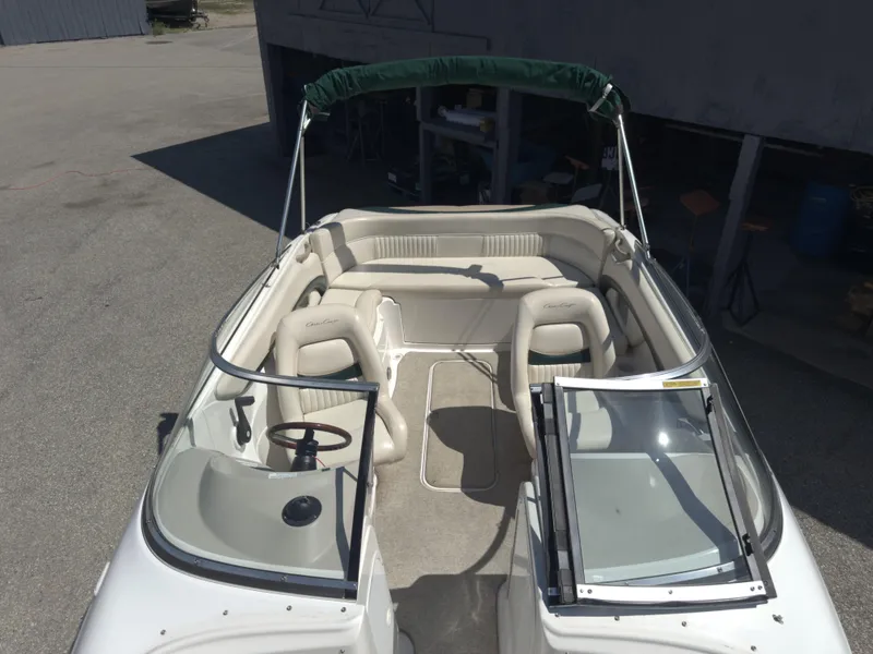 Slide: The Image of 1999 Chris-Craft 210 Bowrider boat interior with beige seating and green canopy. - 9
