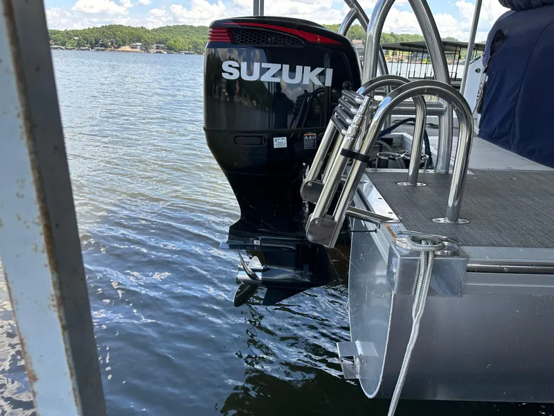 Slide: The Image of 2017 JC 25 Neptoon TT Sport pontoon with Suzuki outboard motor on a lake. - 4
