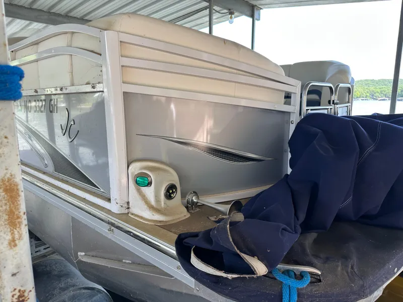 Slide: The Image of 2017 JC 25 Neptoon TT Sport pontoon boat docked under a covered area. - 6