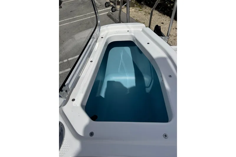Slide: The Image of 2025 Yamaha Boats 252 FSH Sport storage compartment, open and empty, with blue interior. - 24
