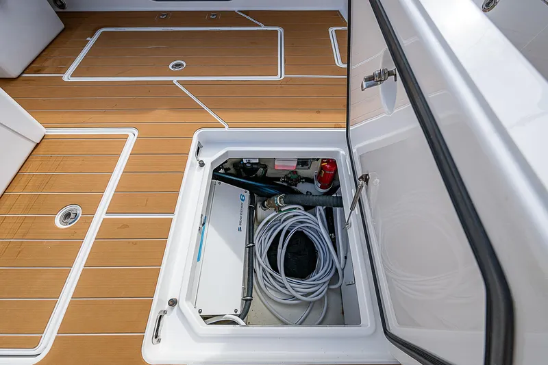 Slide: The Image of 2022 HCB 53 boat storage compartment with teak flooring and equipment. - 17