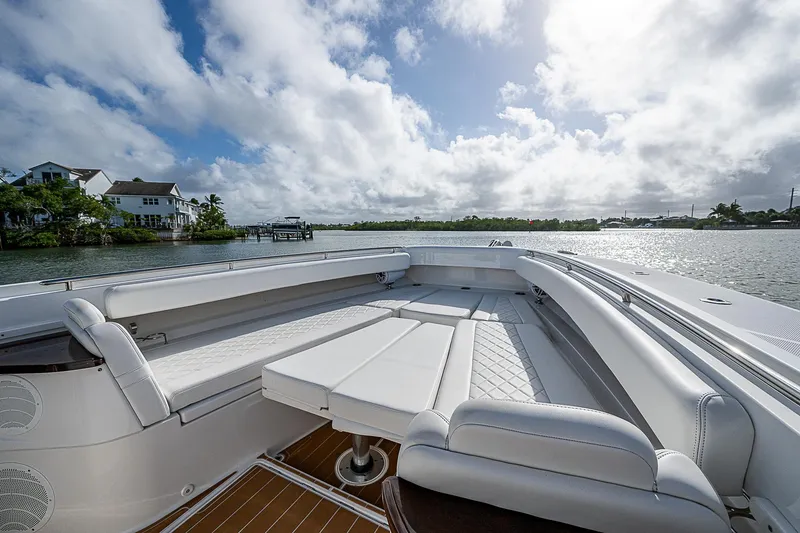 Slide: The Image of 2022 HCB 53 boat with spacious seating, docked by a scenic waterfront. - 5