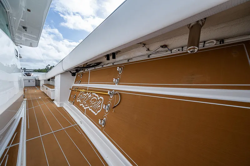 Slide: The Image of 2022 HCB 53 boat deck with brown flooring and white accents under a cloudy sky. - 8