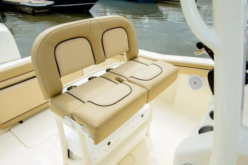 Slide: The Image of Manufacturer Provided Image: 2025 Scout 215 XSF boat with tan cushioned seating by the water. - 12