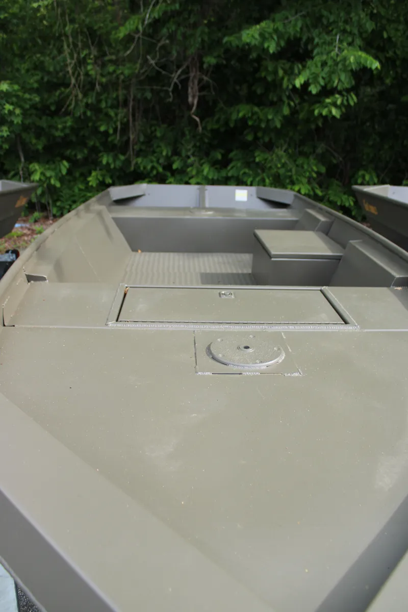 Slide: The Image of 2025 WeldBilt 1548V boat with open deck, surrounded by lush greenery. - 2