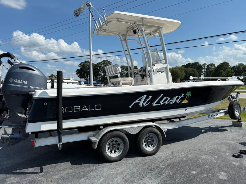 Slide: The Image of 2017 Robalo 226 Cayman boat on trailer with Yamaha engine, under clear blue sky. - 2
