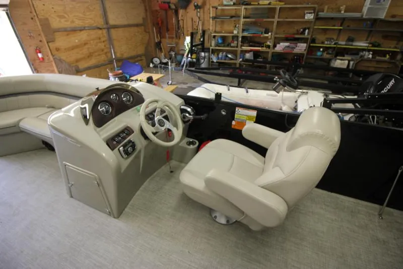 Slide: The Image of 2017 South Bay 222 CR boat interior with steering console and seating in a garage. - 6