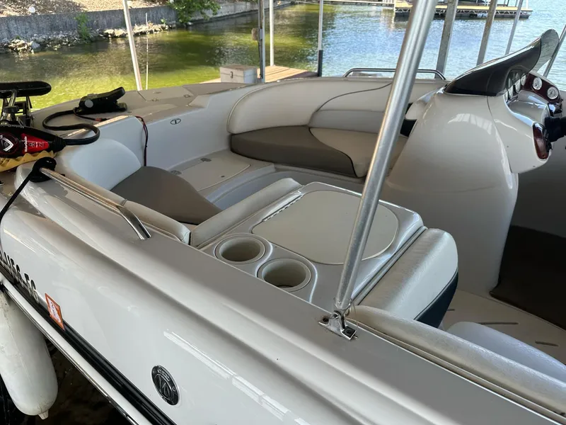 Slide: The Image of 2005 Tahoe 195 OB boat interior with seating and steering wheel, docked by the water. - 28