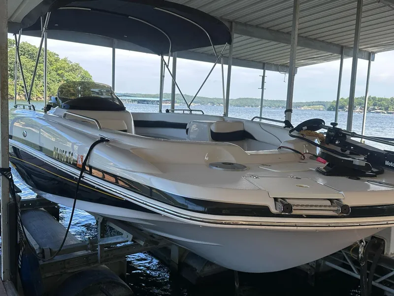 Slide: The Image of 2005 Tahoe 195 OB boat docked under a canopy on a lake. - 30