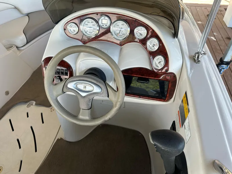 Slide: The Image of 2005 Tahoe 195 OB boat dashboard with steering wheel and gauges. - 34