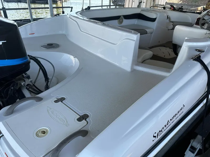 Slide: The Image of 2005 Tahoe 195 OB boat interior with seating and motor, docked by the water. - 35