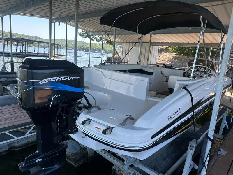 Slide: The Image of 2005 Tahoe 195 OB boat with outboard motor docked under a canopy. - 43