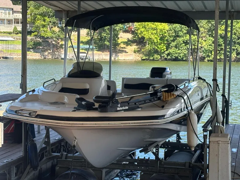 Slide: The Image of 2005 Tahoe 195 OB boat docked under a canopy on a sunny day. - 44