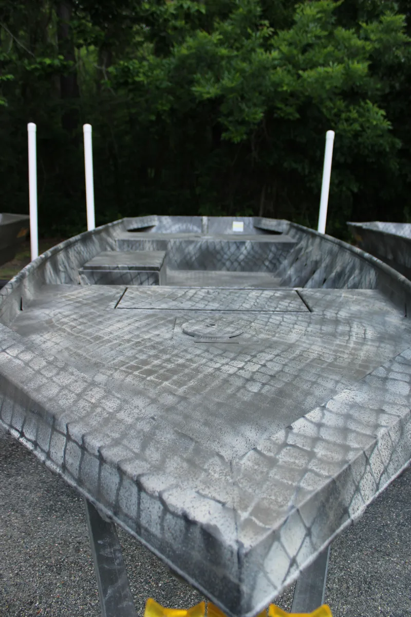 Slide: The Image of 2025 WeldBilt 1648V aluminum boat with textured surface, set against a forest backdrop. - 1