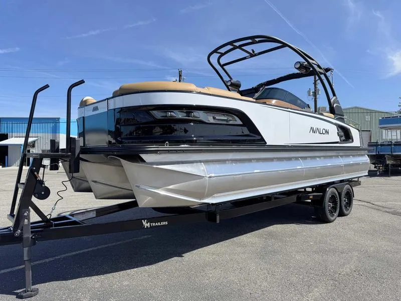 Slide: The Image of 2025 Avalon 2585 27-3 Excalibur LTD QL pontoon boat on trailer, parked outdoors. - 16