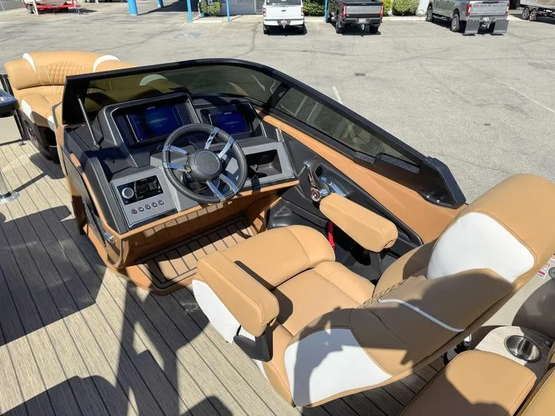 Slide: The Image of Luxurious 2025 Avalon 2585 Excalibur LTD QL boat interior with modern helm and tan seating. - 18