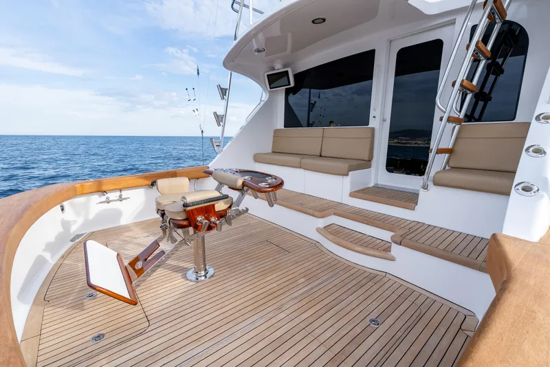 Slide: The Image of Luxurious 2010 Hatteras 60 Convertible yacht deck with seating, ocean view, and fishing equipment. - 11