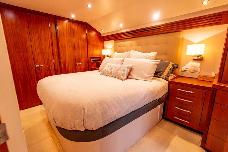 Slide: The Image of Luxurious bedroom interior of 2010 Hatteras 60 Convertible yacht with wood accents and cozy lighting. - 32