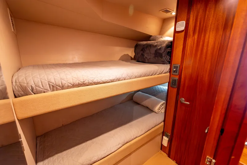 Slide: The Image of Bunk beds in 2010 Hatteras 60 Convertible yacht cabin with wooden door and cozy bedding. - 38