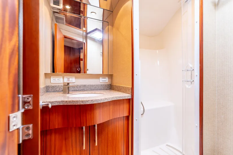 Slide: The Image of Luxurious bathroom in 2010 Hatteras 60 Convertible yacht with modern fixtures and wood accents. - 45