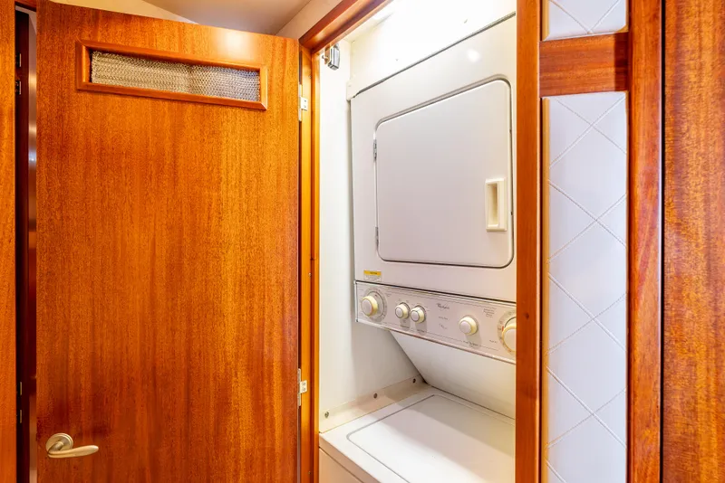 Slide: The Image of Laundry area with stacked washer and dryer inside 2010 Hatteras 60 Convertible yacht. - 46