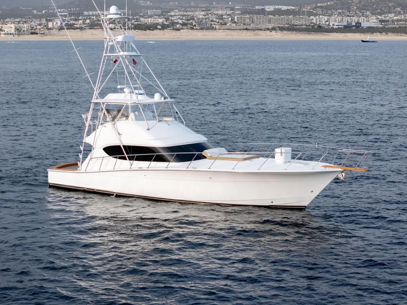 Slide: The Image of 2010 Hatteras 60 Convertible yacht on open water, coastal city in background. - 5