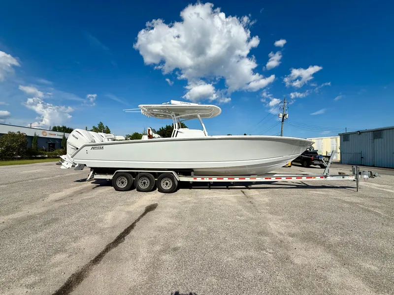 Slide: The Image of 2026 Jupiter 34 boat on trailer under clear blue sky. - 0