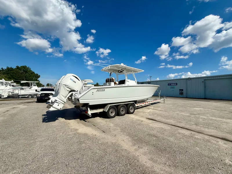 Slide: The Image of 2026 Jupiter 34 boat on trailer under clear blue sky. - 1