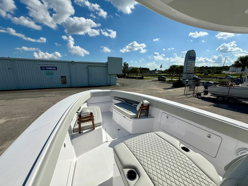 Slide: The Image of Luxurious 2026 Jupiter 34 boat interior with cushioned seating under a clear blue sky. - 12