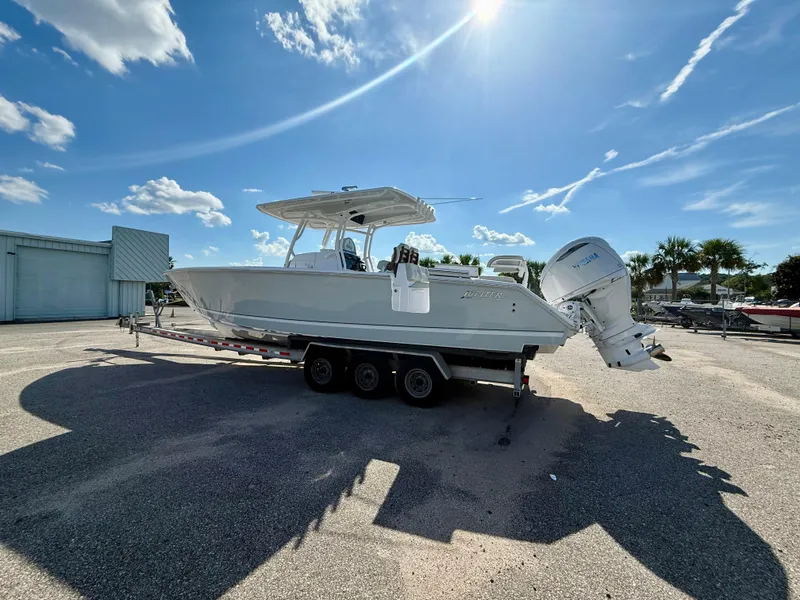 Slide: The Image of 2026 Jupiter 34 boat on trailer under clear blue sky. - 3