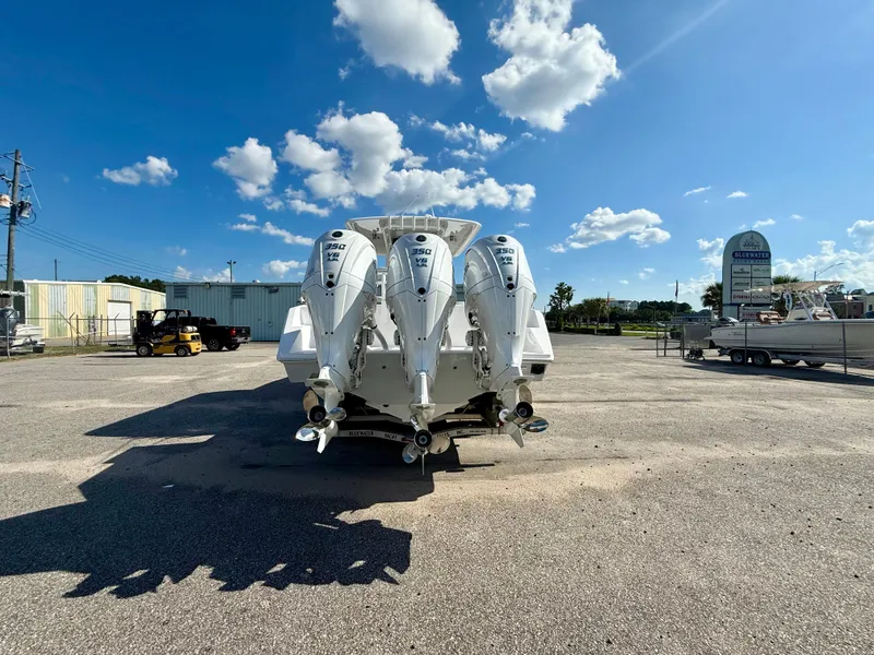 Slide: The Image of 2026 Jupiter 34 boat with triple 350 V8 engines, parked under a clear blue sky. - 4