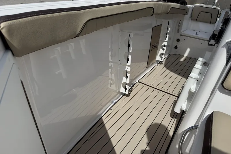 Slide: The Image of 2025 Yamaha Boats 252 FSH Sport interior with cushioned seating and sleek flooring. - 18