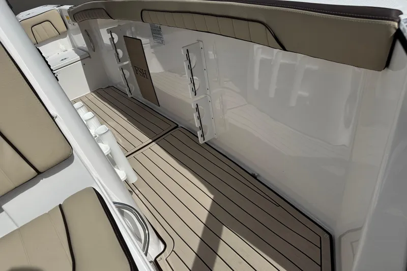 Slide: The Image of 2025 Yamaha Boats 252 FSH Sport interior with cushioned seating and rod holders. - 19
