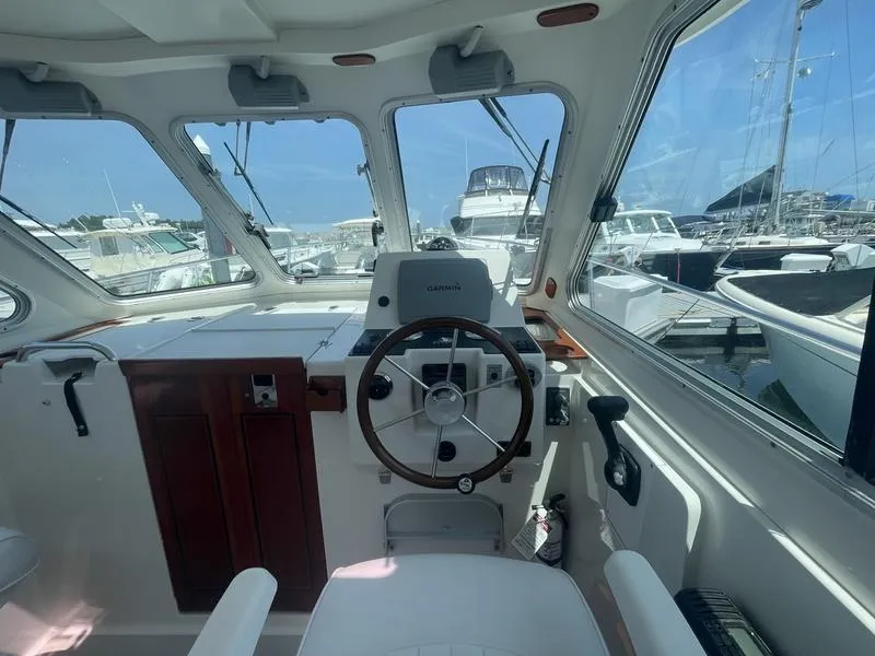 Slide: The Image of 2006 Back Cove 29 boat helm with steering wheel and Garmin navigation, docked at marina. - 3