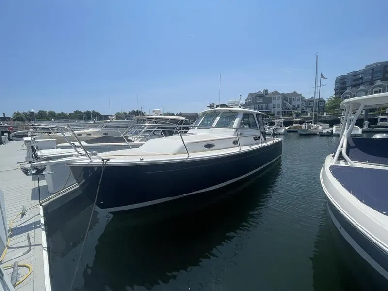 Slide: The Image of 2006 Back Cove 29 boat docked at a marina under clear blue skies. - 37